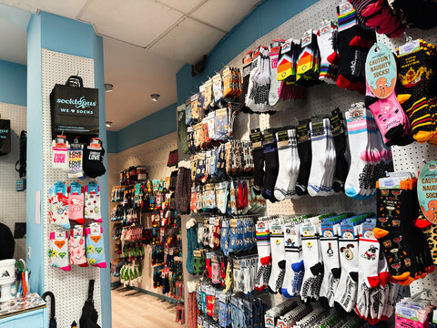 Colorful sock shop display in a boutique retail store in Edinburgh, Scotland, UK with patterned socks and novelty hosiery on pegboard walls