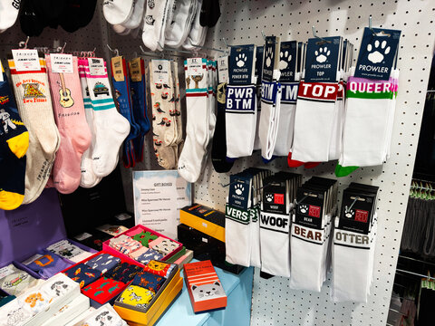 Colorful novelty socks display in a gift shop in Edinburgh, Scotland, UK showing branded crew socks, gift boxes and hanging pairs on a pegboard