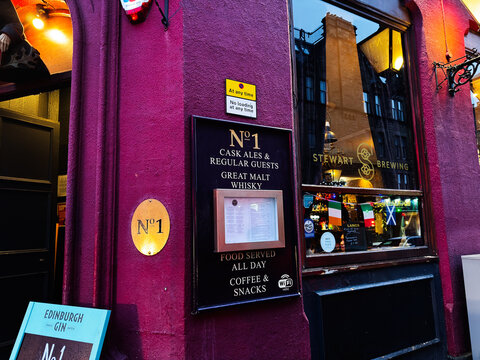 No1 pub facade with cask ales and great malt whisky at Stewart Brewing in Edinburgh, Scotland, UK cozy evening exterior with menu and window reflections