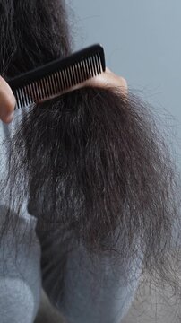 woman sticking brushing her hair falling out and have many hair loss on the comb. problem of Damaged and frizzy. Healthcare and medical concept.