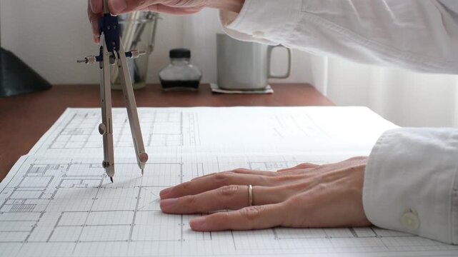 建築士が製図作業を行う手元　コンパスを使った建築設計図の作成 An architect working on a drawing	