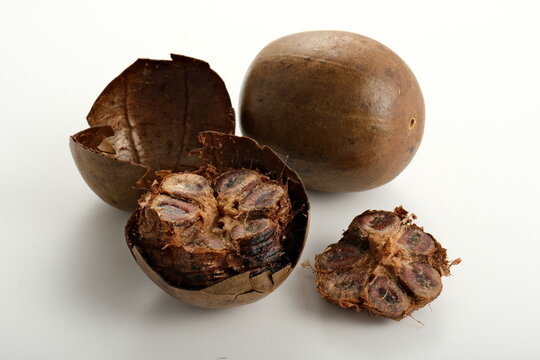 Whole and halved luo han guo fruits with detailed cross-section showing seeds and outer shell on white background