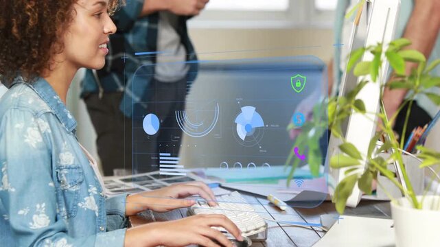 Woman typing at keys in design studio, team gesturing and causing holographic UI shifting, smiling