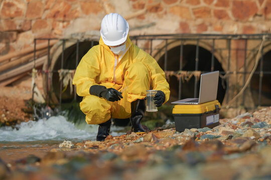 Environmental sampling action by scientist riverbank field research urban environment close-up view water quality assessment