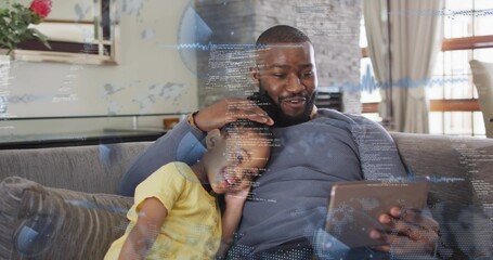 Naklejka premium Cradling father in sweatshirt holding tablet with daughter in yellow top in living room, AR overlay