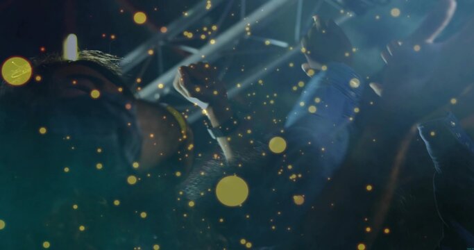 Raising arms, three concertgoers cheering at concert, showing denim sleeve, wristwatch, stage beams