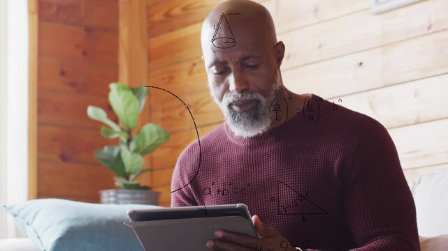Mature man tapping tablet, initiating animated math diagrams growing across wood wall learning