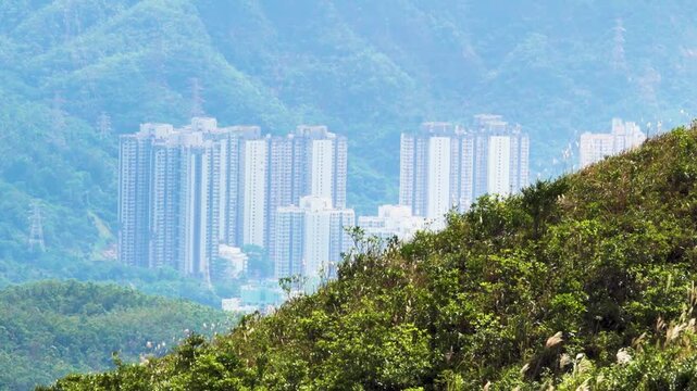 Hong Kong on hills surrounded by tropical forest. Megacity high-rise residential buildings and residential neighborhoods. Increasing population density due to upward housing growth