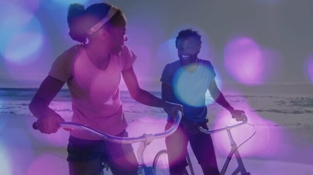 Bokeh overlay starting as woman and man laughing and leaning on bicycles, marketing beach lifestyle