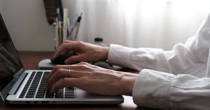 Hands using laptop and mouse at home desk, remote work and productivity concept　自宅デスクでノートパソコンとマウスを操作する手元 リモートワークと作業効率のイメージ