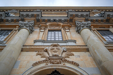 Low angle view of the ornate Baroque facade and stone columns of the Royal Palace in Stockholm, featuring the golden Three Crowns heraldic symbol. © Denis Rozhnovsky