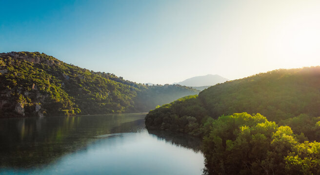 Canoeing and sup standup paddleboarding at  mountains Ziros lake in Preveza Greece at sunrise.