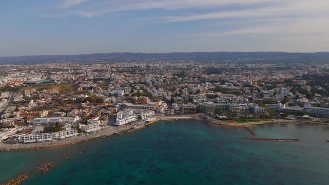 Aerial Orbit of Paphos Coastline Showing Modern Boardwalk and Historic Lighthouse in Cyprus