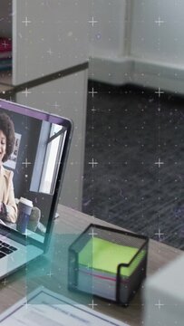 Vertical video: Woman in laptop starting business call, animated HUD moving over desk marking notes