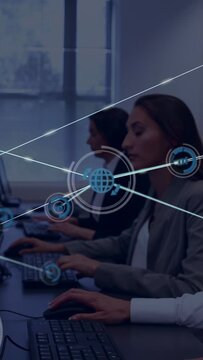 Vertical video: Right worker typing while peer with paper causing blue mesh showing tech data flow
