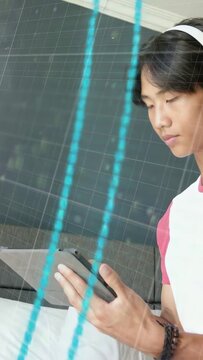 Vertical video: Teenager tapping tablet, initiating neon rings and smiling while exploring tech