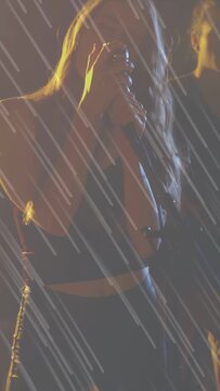 Vertical video: Female singer cam pullup raising mic, singing duet for crowd under rain overlay