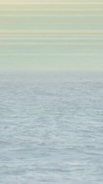 Vertical video: Shot shifting from surf to horizon, sea shifting ripples into swells for calm scene