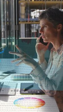 Vertical video: Woman designer on phone typing and gesturing syncing graphs with palette for review
