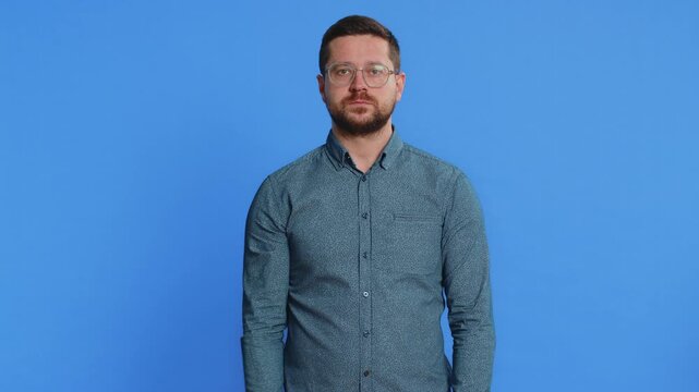 Displeased upset man in shirt reacting to unpleasant awful idea, dissatisfied with bad quality, wave hand, shake head No, dismiss idea, don't like proposal. Young guy isolated on blue background