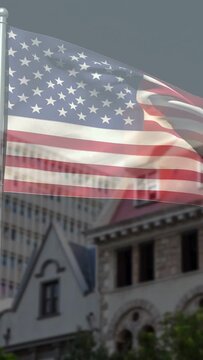 Vertical video: US flag billowing from wind, folding and fluttering, hiding and revealing facades