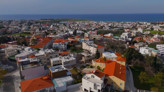 Aerial Drone Flight Over Paphos Old Town Rooftops Toward Mediterranean Coast and Lighthouse Cyprus