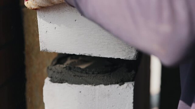 Laying aerated concrete block with mortar joint in wall close up