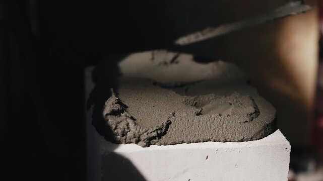 Leveling mortar on aerated concrete block with trowel close up