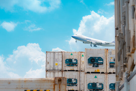 Cargo airplane flying above logistic container. Air logistic. Reefer for frozen food. Refrigerated container for export and import logistics. Freight transport. Aviation business. Merchandise export.