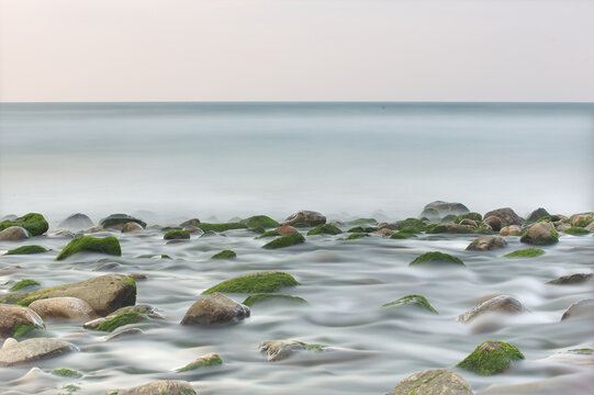Sunset at Playa de Espa&ntilde;a, Asturias. Long exposure of Cantabrian Sea with silky water and rocks. Natural coastal landscape of Northern Spain, Europe.