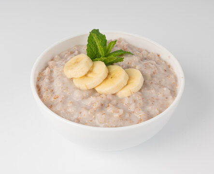 Cooked spelt in bowl isolated. Oatmeal milk porridge with fruits and berries
