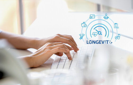 Close-up of hands typing on a laptop with a digital longevity interface overlay, representing modern healthcare technology,  and data-driven approaches to anti-aging and wellness.