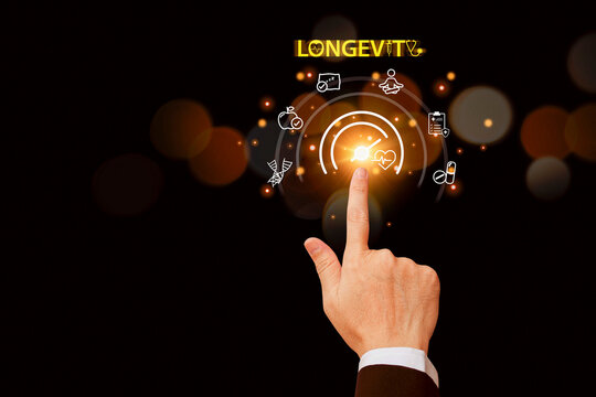 Business hand touching a glowing digital longevity interface on a dark background, symbolizing innovation in health technology, anti-aging solutions, and futuristic data-driven healthcare concepts.