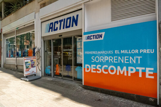 Fachada de tienda minorista Action en calle urbana con carteles publicitarios en Barcelona