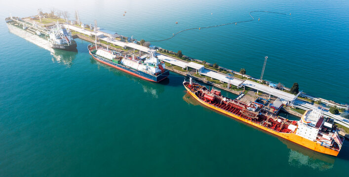 Energy logistics LPG tanker ships, fuel terminal, maritime transport, gas petroleum transfer, industrial port infrastructure, import export supply chain aerial view.