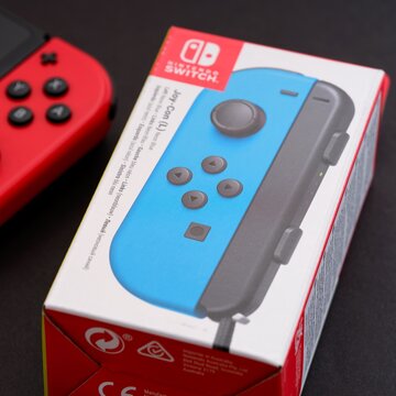 Tambov, Russian Federation - September 28, 2021 Close-up shot of a box for new blue Nintendo Switch Joy-Con controller on black background