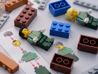 Naklejka premium Tambov, Russian Federation - June 21, 2024 A close-up of Lego minifigures and colorful bricks lying on an assembly instructions.
