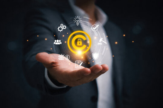 Businessman holding copyright symbol represent intellectual property protection, copyright monitoring, digital rights management, legal compliance and content ownership security.