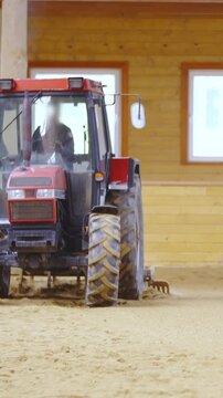 Tractor in riding arena plow through sand in slow motion