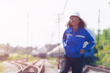 Obraz premium A black female engineer walks the tracks inspecting the readiness of a gas-powered train.