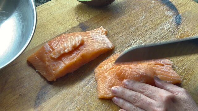 Cutting raw salmon into cubes for poke or tartar