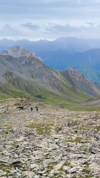 Panning video shows green grasslands on the Old Silk Road trek in Xinjiang, China. Beautifully layered mountains with copy space on top. The idea for adventure footage with copy space.