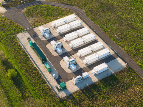 Aerial view of Tiln Photovoltaic Solar Farm and Battery Energy Storage System with rows of white containers and electrical equipment in Retford, England, United Kingdom.