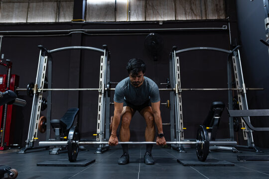 Asian Male athlete lifting deadlift during exercising in gym. Man doing deadlift barbell for Functional training, deadlift exercise and strength training in Gym.