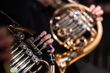 Fototapeta premium Close-up of French horns in the hands of musicians in an orchestra