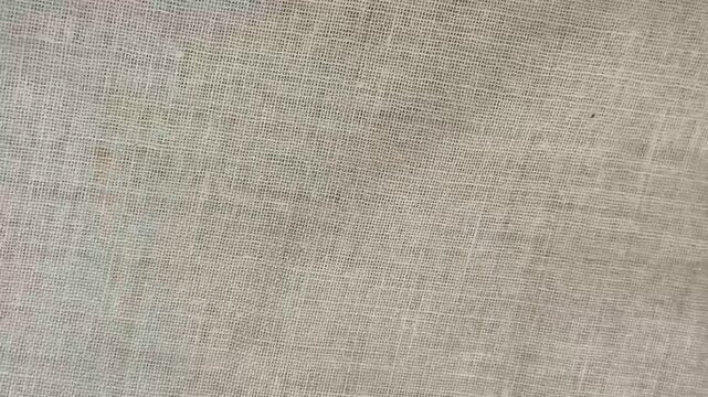 White or lite grey color woven cloth canvas or fabric sheet surface background texture. Plain biodegradable textile material surface abstract background texture stop motion loop animation.