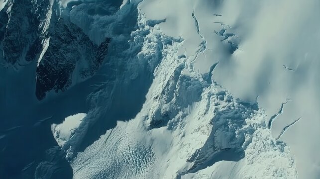 Diminishing glacier ice on a rugged mountain peak viewed from above, showcasing the impact of climate change on icy landscapes.