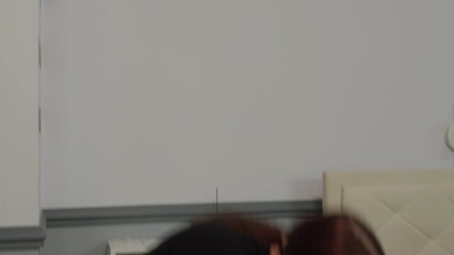 Young woman with long hair in a black crop top performing an emotional contemporary dance. Graceful, fluid movements in a minimalist room. Modern, improvisational, and expressive performance