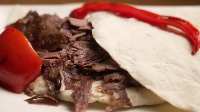Traditional Turkish Doner Kebab served on a plate with pita bread, tomato, and roasted pepper, fa01