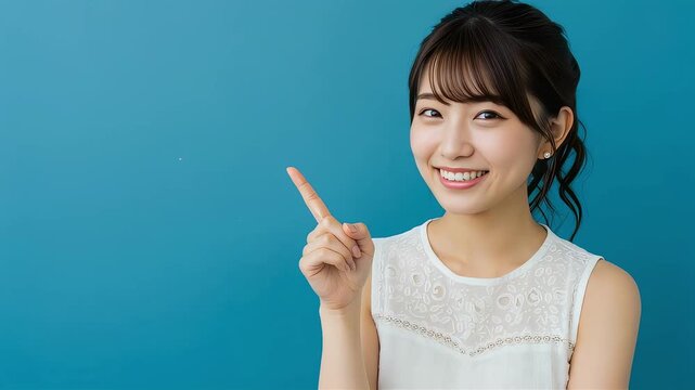 笑顔で上を指差す日本人女性。青背景でポイントを分かりやすくアピール。